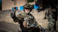 Ein maskierter Soldat lässt eine Mini-Drohne vom Typ Black Hornet 4 aus der Hand aufsteigen.