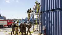 Personen in Feuerwehrkleidung und Uniform arbeiten zusammen.