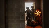 Zwei Soldaten kämpfen mit dem Maschinengewehr aus einem Fenster heraus.