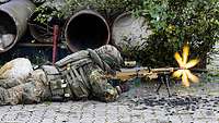 Ein Soldat liegt auf dem Boden und schießt mit einem Gewehr