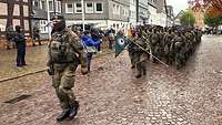 Die Missionsabstellung läuft in Formation mit Truppenfahne auf dem Marktplatz ein.