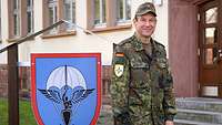 Militärpfarrer Markus Konrad vor dem Wappen der Kaserne in Zweibrücken