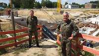 Generalleutnant Helmut Schütz (rechts) und Brigadegeneral Michael Traut stehen mit dem Rücken zur Baustelle.