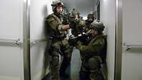 Soldaten mit ihren Waffen sichern den Gang in einem Schiff
