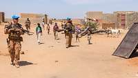 Deutsche Soldaten auf Fußpatrouille begleitet von malischen Kindern