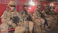 Mehrere Soldaten der Bundeswehr sitzen mit Gepäck in einem Hubschrauber