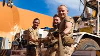 Drei Bundeswehrsoldaten ziehen an einem Seil und schauen in die Kamera