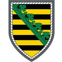 Neunfach schwarz und gold geteilt, belegt mit einem diagonalen grünen Rautenkranz, silbern umrandet.