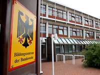 Das Bildungszentrum der Bundeswehr Ein Gebäude mit vielen Fenstern von außen. Links im Bild ist ein Wappen mit dem Bundesadler.