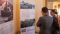 Zwei Soldaten sehen sich die Schautafeln an 