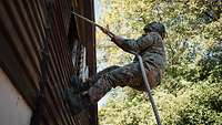 Ein Soldat seilt sich aus einem Fenster ab.