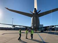 Piloten beim Sicherheitscheck Drei Piloten gucken sich das Heck eines Flugzeugs an.