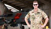 Ein Soldat steht vor einem Tornado und lächelt
