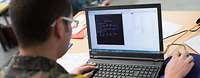 Ein Soldat bei der Cyber Defence NATO Übung Locked Shields. Ein Bundeswehrsoldat sitzt vor einem geöffneten Laptop