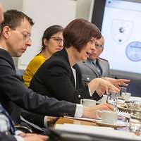 Mehrere Personen sitzen an einem Tisch und sprechen miteinander