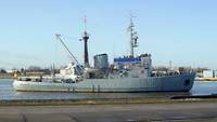 Ein graues Boot fährt über ein Gewässer.