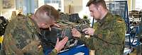 ZAW Ausbildung Luftfahrzeugtechniker in Kassel Zwei Soldaten schrauben an einem Triebwerk in einem Unterrichtsraum.