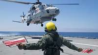 Der Bordhubschrauber landet auf dem Flugdeck der Fregatte