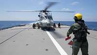 Der gelandete Hubschrauber wird auf dem Flugdeck befestigt