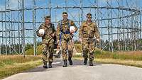 Soldaten aus Stadum vor einer Antennenanlage Soldaten laufen zurück von einer Wartung der Antennenanlagen