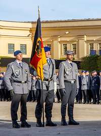 Change of command ceremonies are an indication of change in the Bundeswehr Medical Service organisation Three service men in basic dress, the one in the middle holds the flagpole with the Federal Institutions Flag