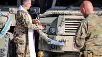Militärdekan Mirko Zawiasa segnet ein Fahrzeug mit Weihrauch