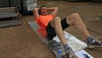 Nils W. liegt auf einer Isomatte und macht Sit-ups