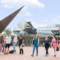 Junge Frauen und Männer in der Ausbildung laufen über einen Platz.