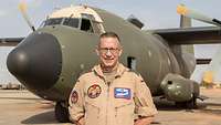 Ein Soldat steht vor einem Flugzeug vom Typ Transall C-160