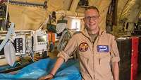 Ein Soldat steht im Flugzeug an einer Krankentrage