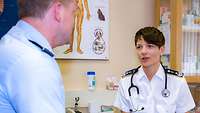 Eine Ärztin sitz gegenüber von einem Patienten