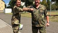 Two men greet each other with the elbow bump