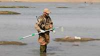 Soldat steht in einem Fluss
