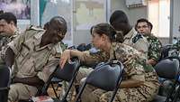 Eine deutsche Soldatin unterhält sich mit einem Soldaten aus dem Senegal