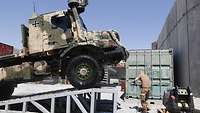 Ein Soldat wäscht einen Lkw vom Typ Zetros
