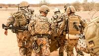Soldaten tragen einen Verwundeten.