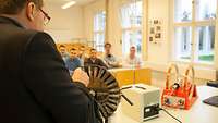 EinMann unterrichtet eine Klasse.