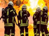 Flugzeugbrandbekämpfung Vier Feuerwehrleute der Bundeswehr löschen lodernde Flammen