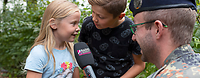 Einen Radiogruß in den Einsatz schicken Zwei Kinder sprechen einen Gruß in ein Mikrofon ein.