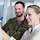 Frau und Soldat stehen vor Flipchart