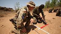 Ein deutscher Soldat bei der Ausbildung zur Minensuche malischer Soldaten