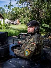 Ein Bundeswehrsoldat schaut aus der Luke eines Panzers