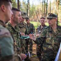 Soldaten stehen im Wald und unterhalten sich