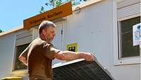 Ein Soldat hebt einen Deckel auf einen Kunststoffcontainer