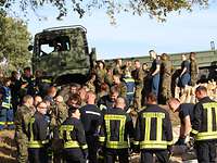Soldaten der Bundeswehr und der polnischen Armee sowie Angehörige des Technischen Hilfswerkes beim Verladen von Sandsäcken.