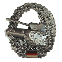 Ovales Zeichen, in der Mitte ein Kampfpanzer, umgeben von Eichenlauf, unten die Deutschlandfahne