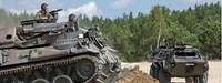 Ein Pionierpanzer schiebt mit seinem vorn angebrachten Räumschild Erdmasse vor sich her.