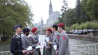 Soldaten mit Kerzen auf einer Brücke vor der Lichterprozession in Lourdes