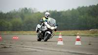 Ein Motorradfahrer auf einem Motorrad fährt durch einen Parcours.