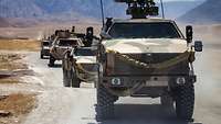 Dingo fahren hintereinander auf einer Schotterstraße in Afghanistan